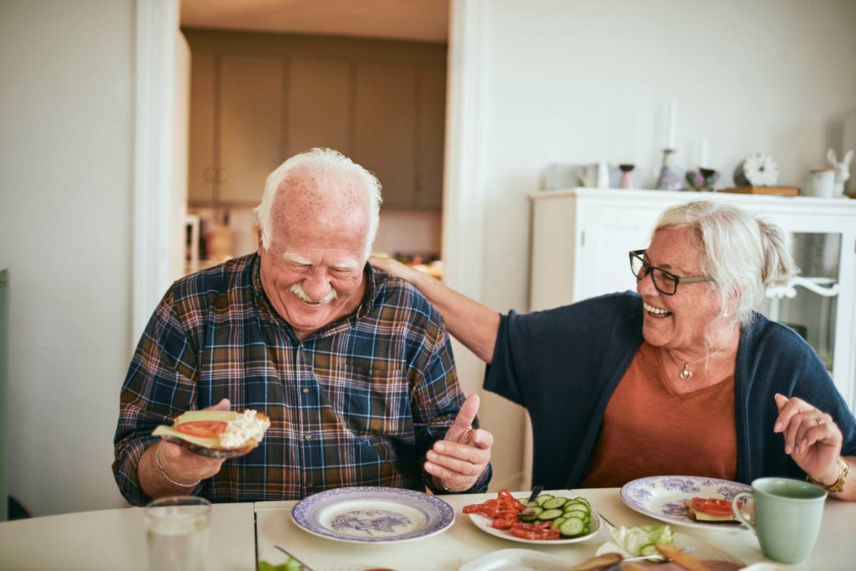 Couple have a laugh while eating healthy food