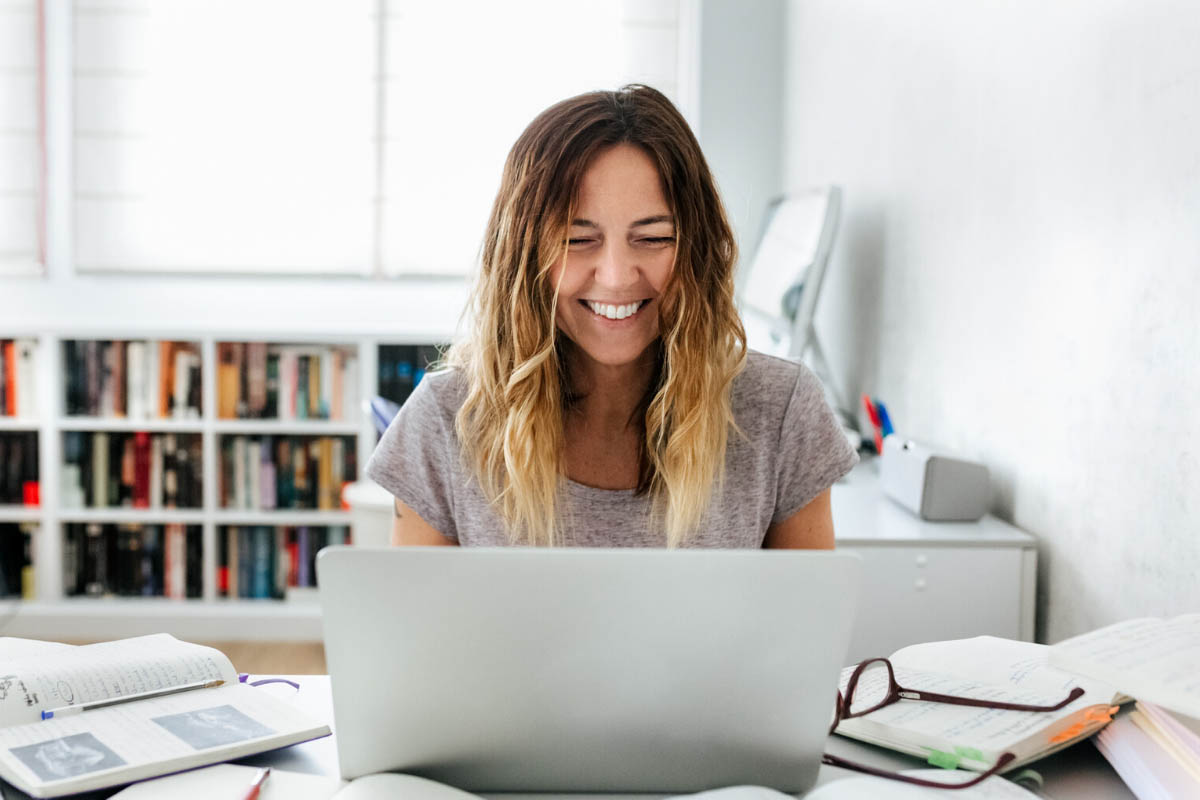 Woman joyfully working on her laptop