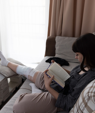 Woman recovering from ACL reconstruction reading a book