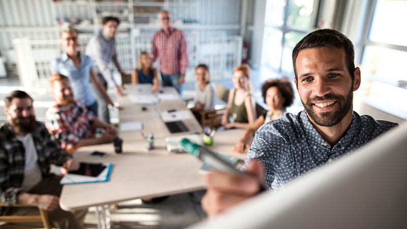 Young professionals looking at whiteboard