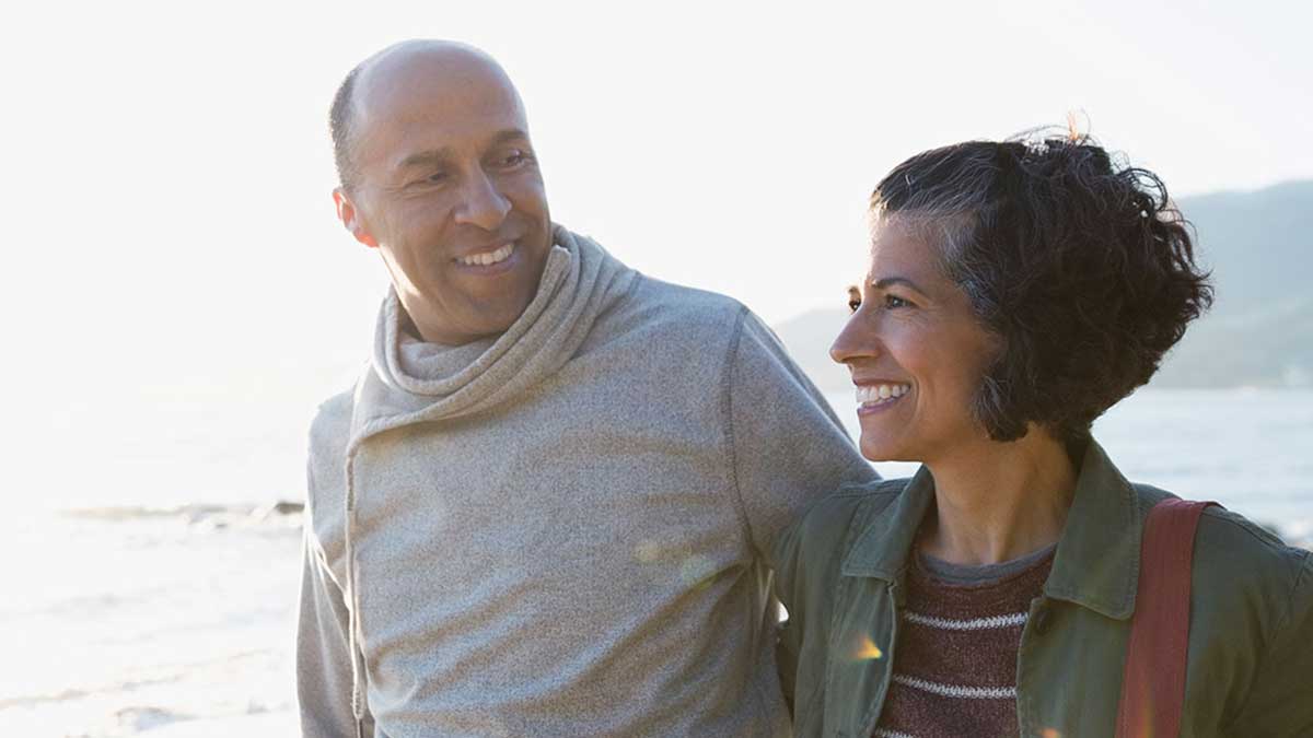 Happy couple walking along beach