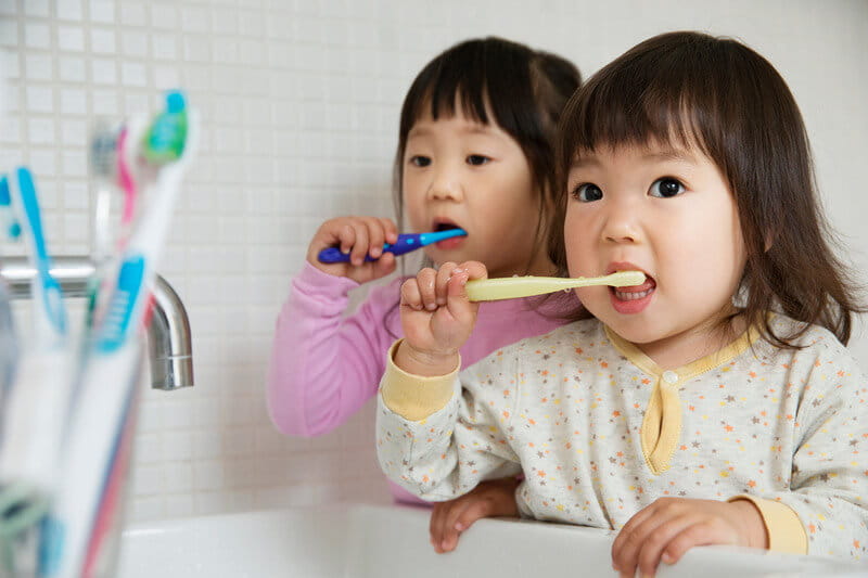 Siblings brushing teeth together before bed
