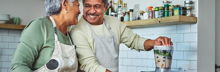 Couple in the kitchen using the blender