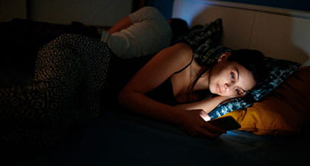 Woman on phone before sleeping